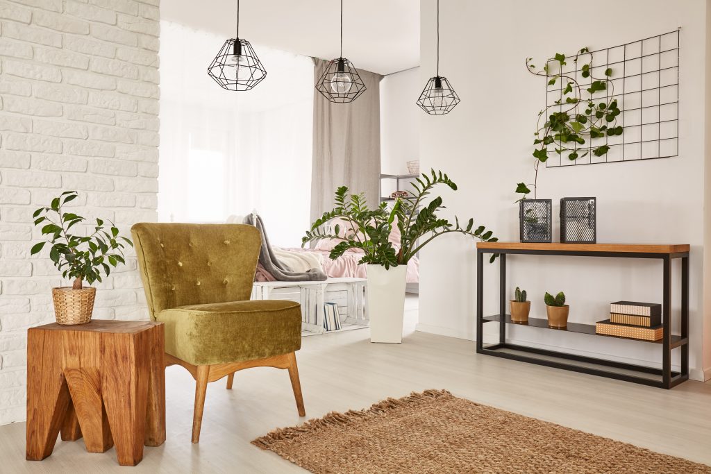 White room with green armchair and wooden side table