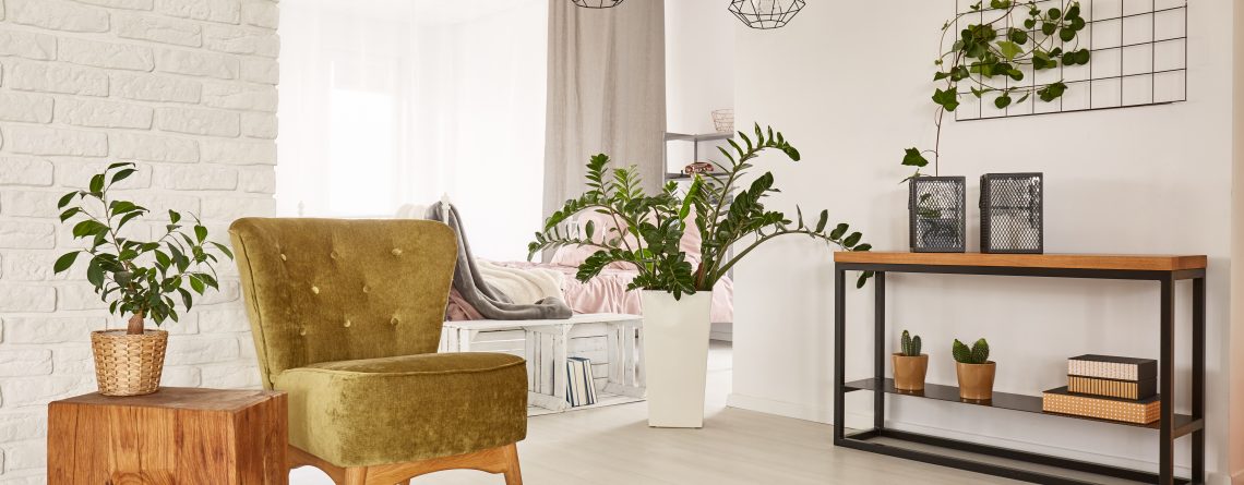 White room with green armchair and wooden side table