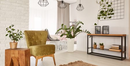 White room with green armchair and wooden side table