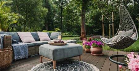 Garden patio decorated with Scandinavian wicker sofa and coffee table