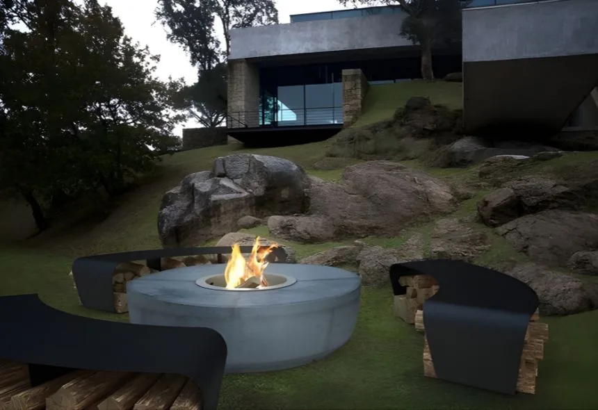 Outdoor bioethanol fireplace pit by GlammFire, circular concrete design with flame, modern benches and stacked firewood, set in landscaped garden beside contemporary house.